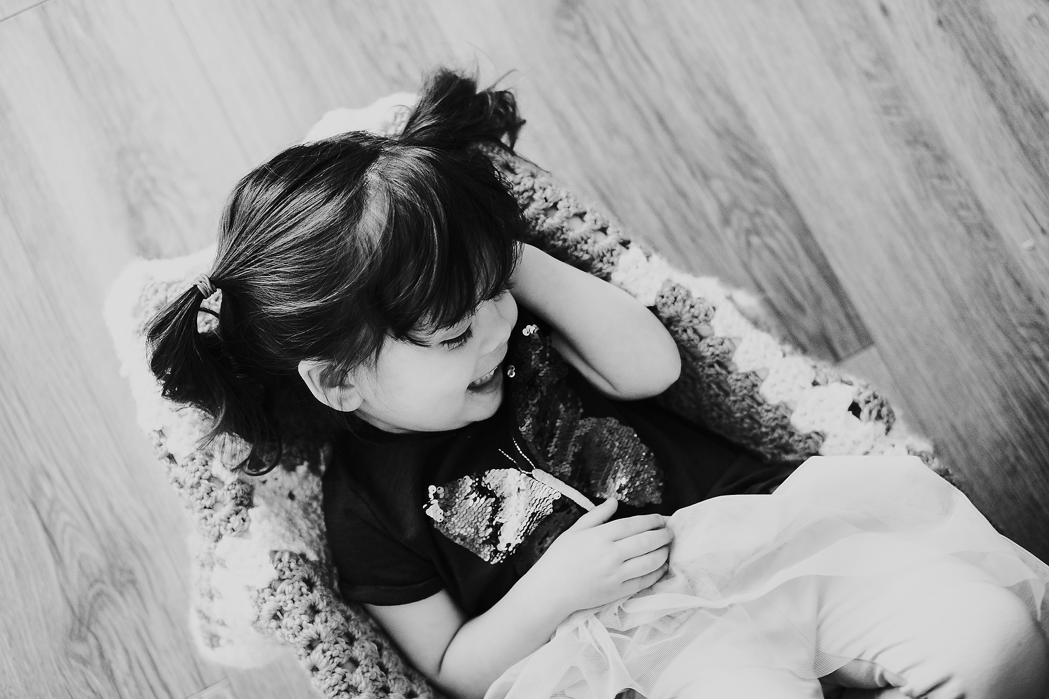 home scene of little girl playing with blanket on the floor islington family photographer shoot black and white