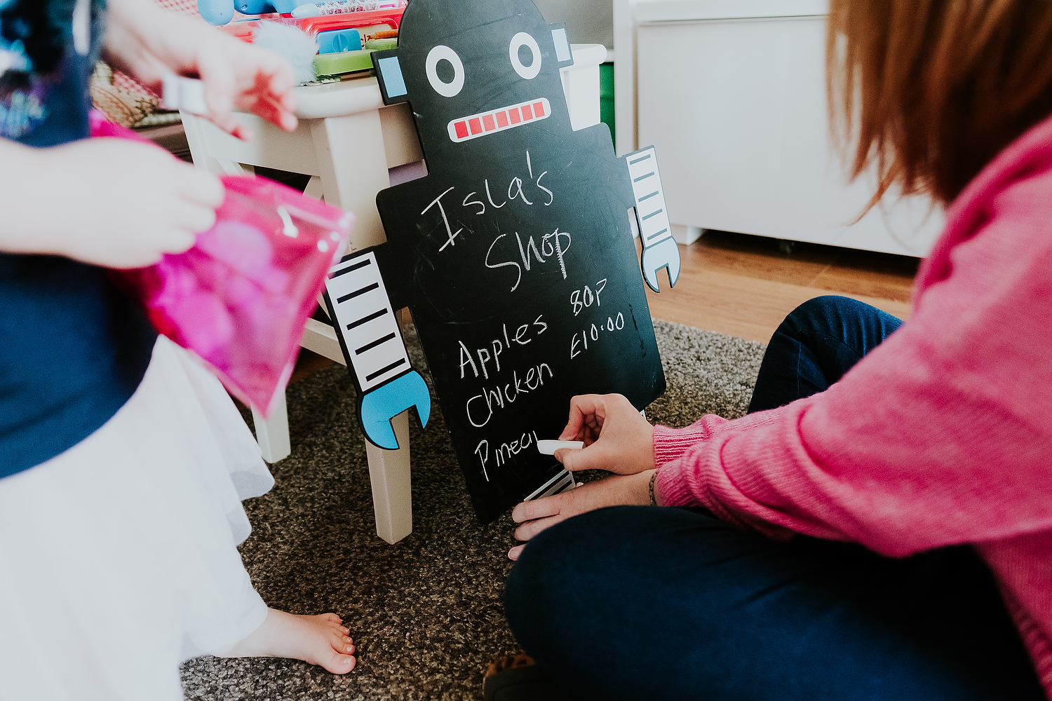 close up mum writing on blackboard for child's make believe play shop islington family photographer