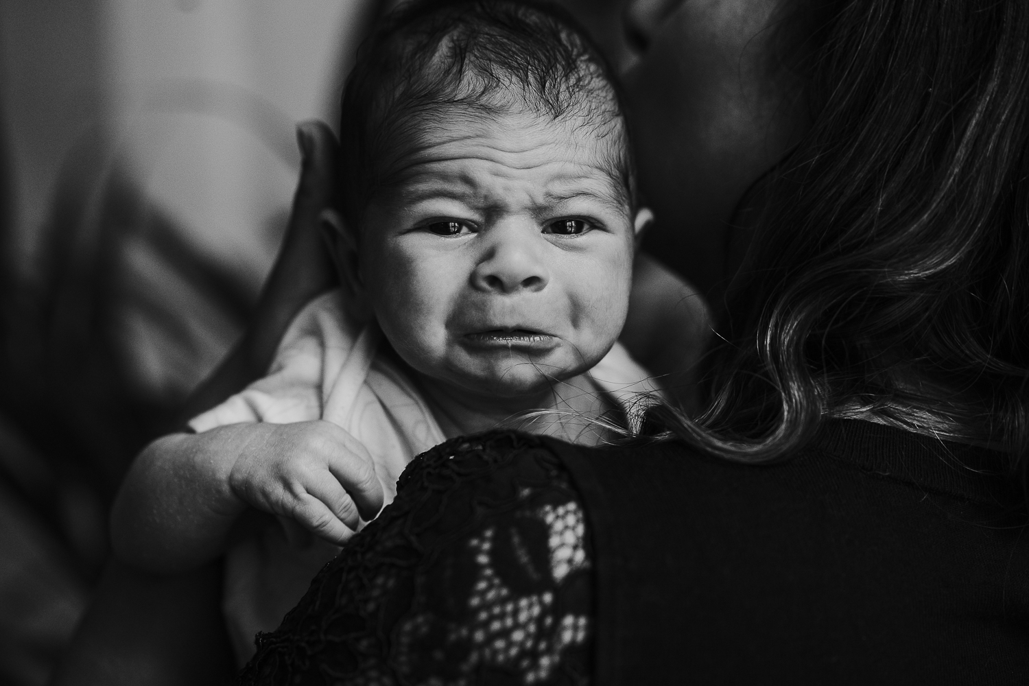 london newborn baby photographer close up of baby's face crying on mum's shoulder