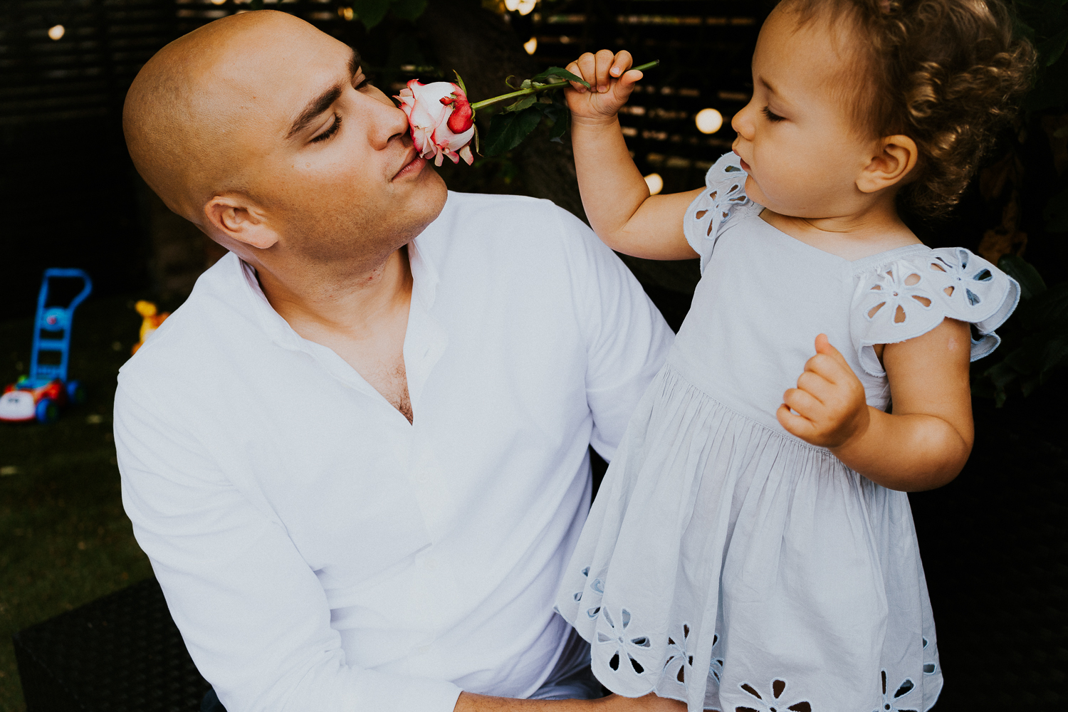 NORTH KENSINGTON FAMILY PHOTO SESSION father and toddler daughter smelling flower
