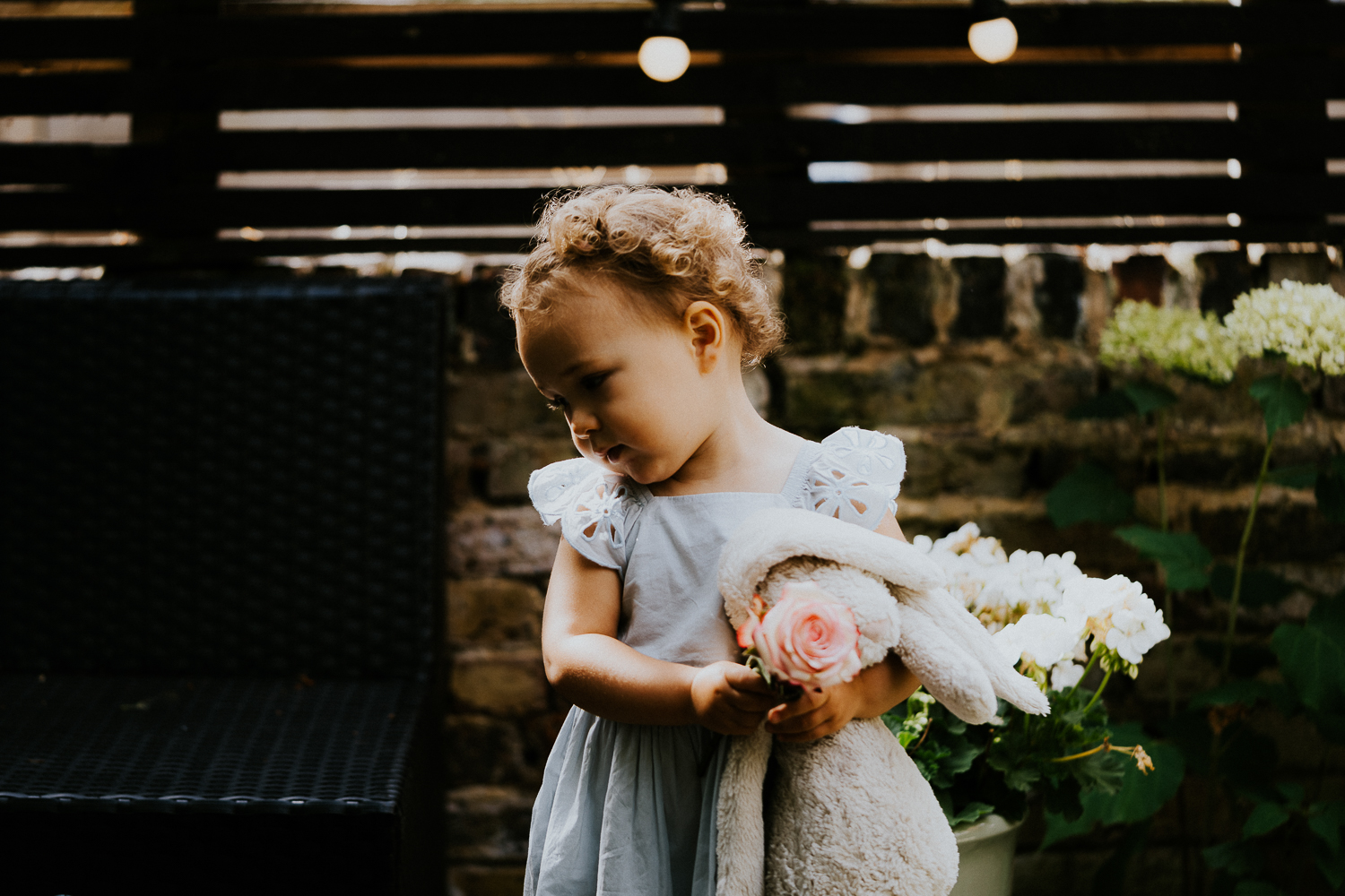 NORTH KENSINGTON FAMILY PHOTO SESSION child moody tantrum in garden holding blanket and stuffed bunny toy