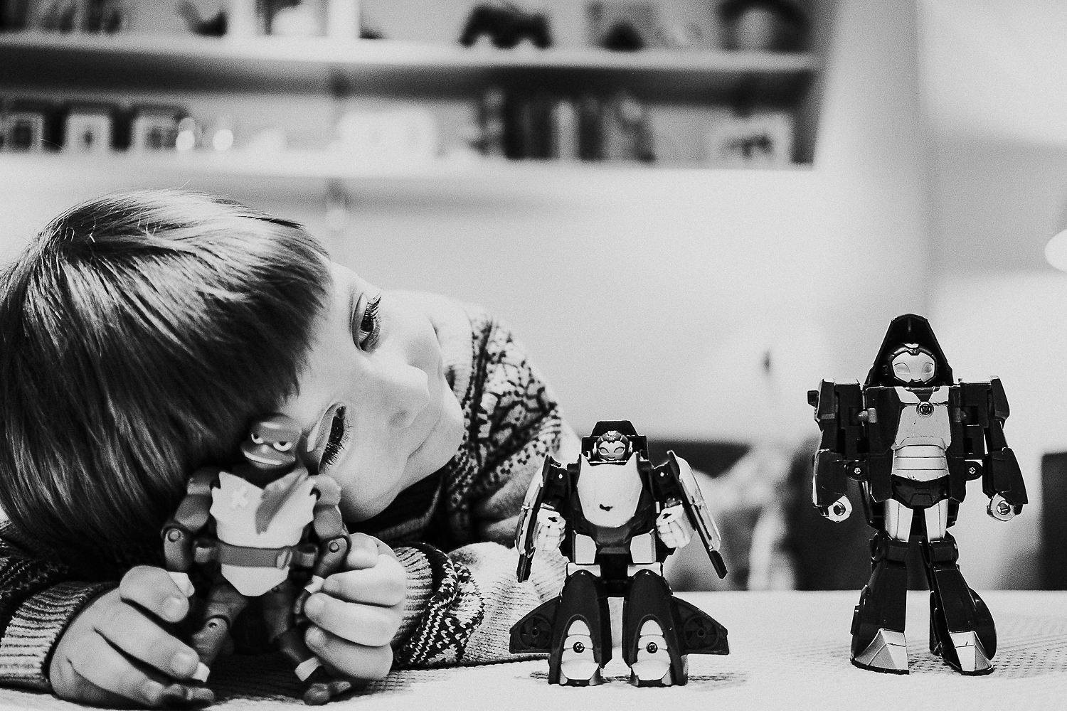 REAL LIFE FAMILY PHOTOS BLACK AND WHITE PHOTO OF LITTLE BOY PLAYING WITH PLASTIC TOY FIGURINES