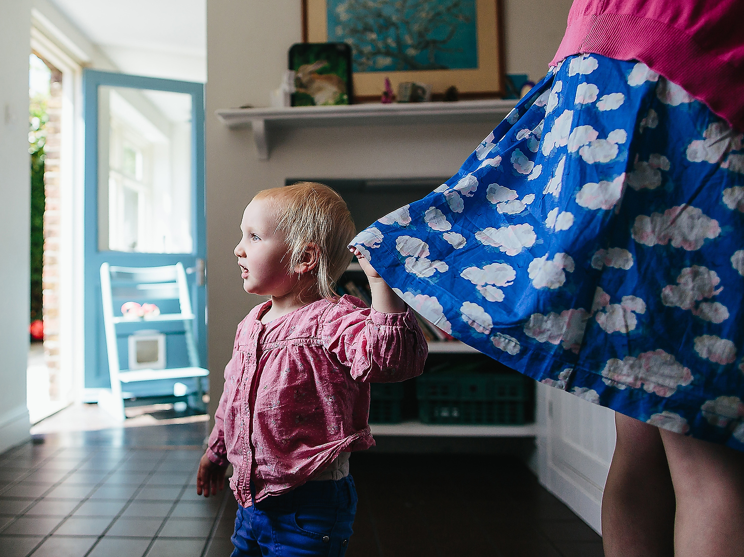 REAL LIFE FAMILY PHOTOS LITTLE TODDLER GIRL HOLDING MOTHERS SKIRT WHILST SHE DOES CHORES IN KITCHEN