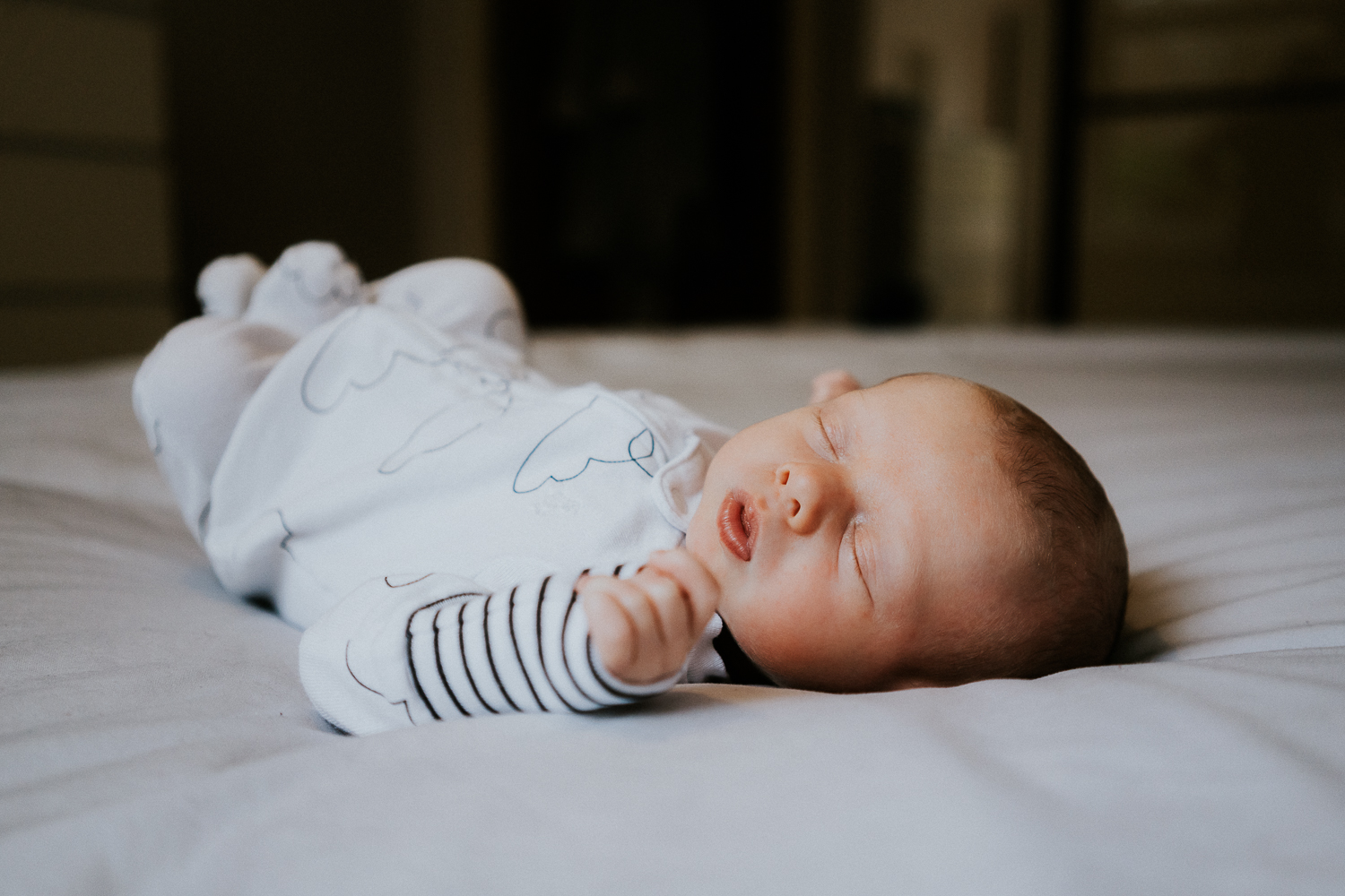 newborn photo session at home in highgate photo of baby boy lying on bed