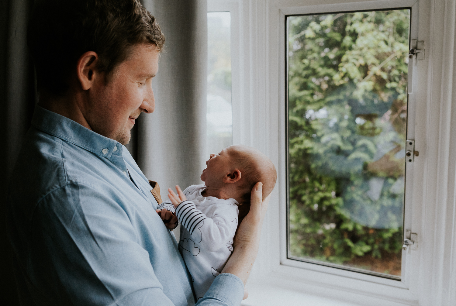 newborn photo session at home in highgate photo of baby boy with father