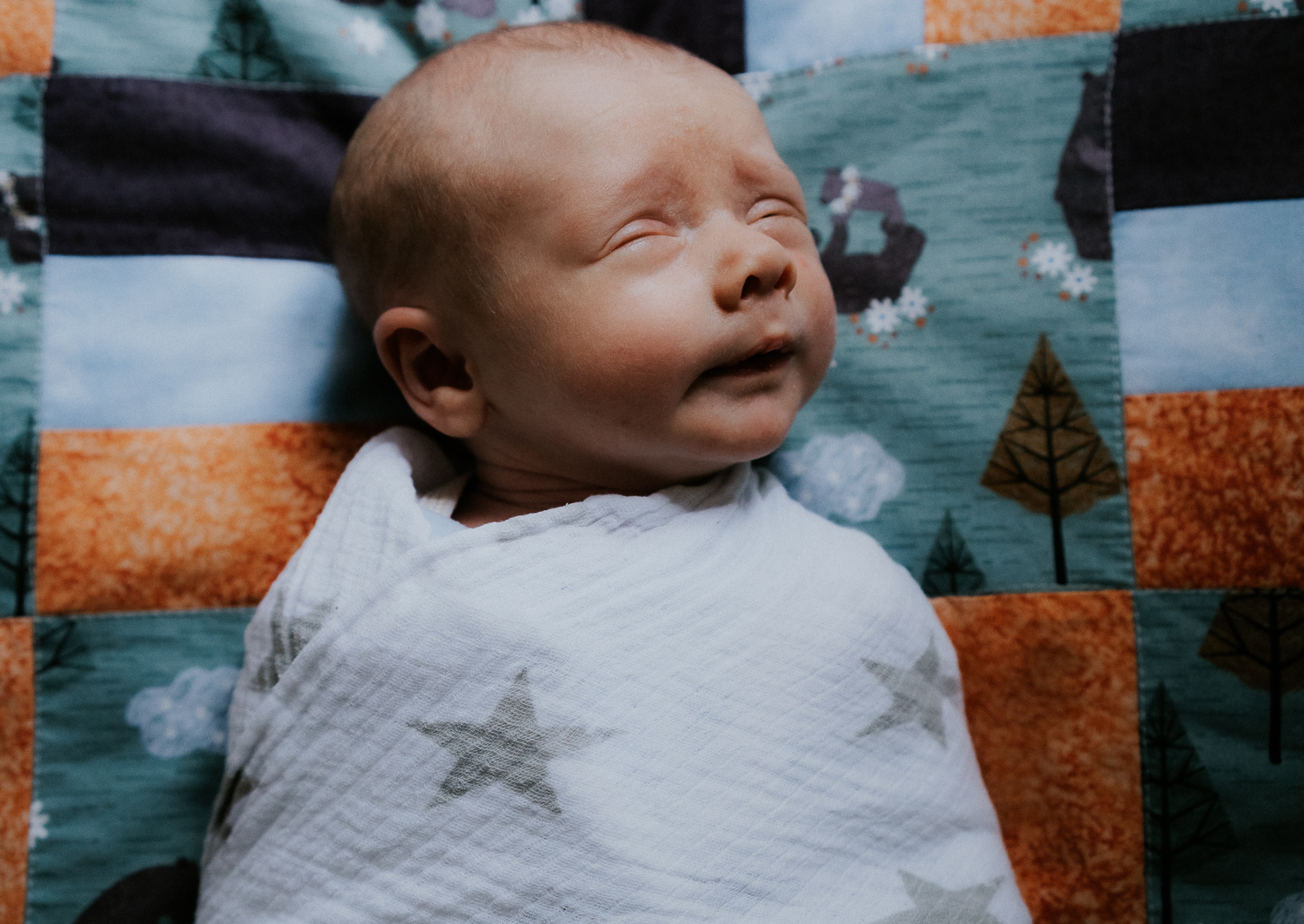 newborn photo session at home in highgate photo of baby boy swaddled on patchwork quilt