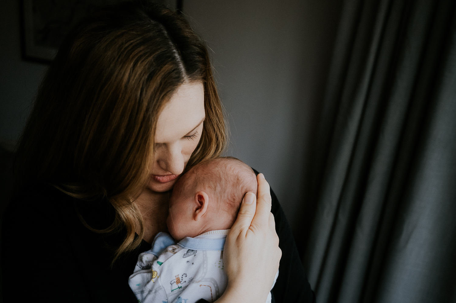 newborn photo session at home in highgate photo of baby boy with mother soothing him