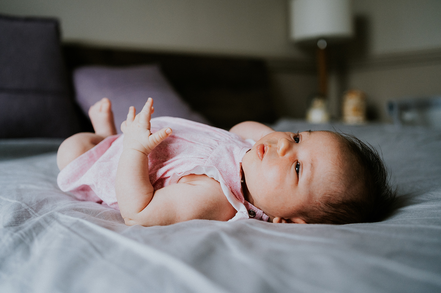 baby lying on bed newborn photography in hammersmith