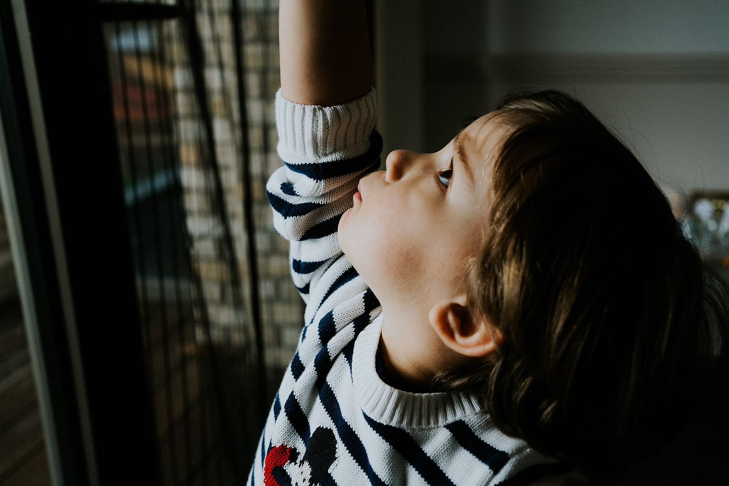 big brother playing near window at home newborn photography in hammersmith