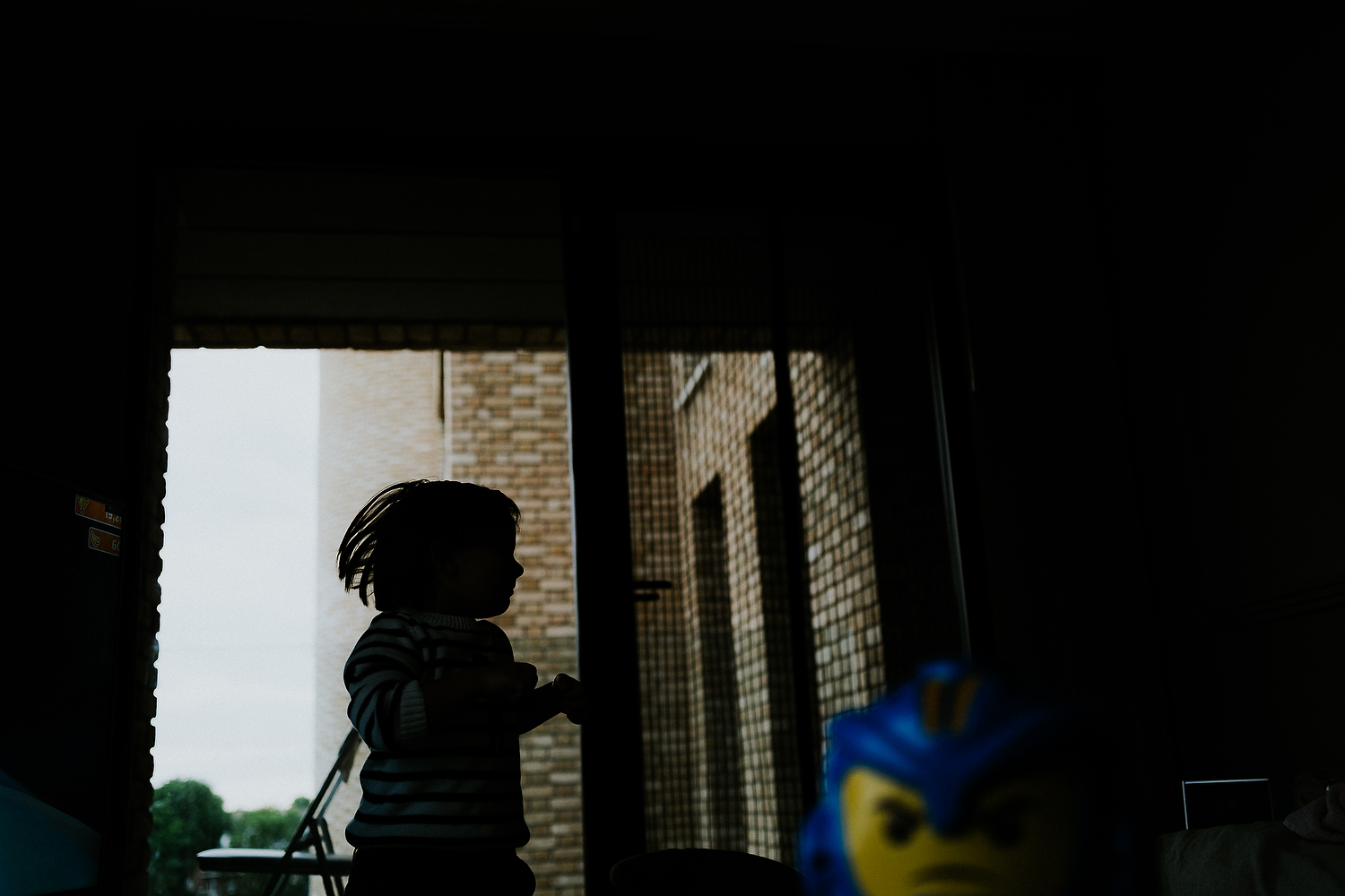 silhouette boy playing with toy in foreground newborn photography in hammersmith