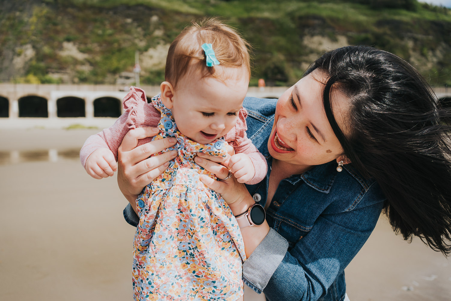 folkestone family photo shoot on the beach black and white photo toddler girl paddling with parents