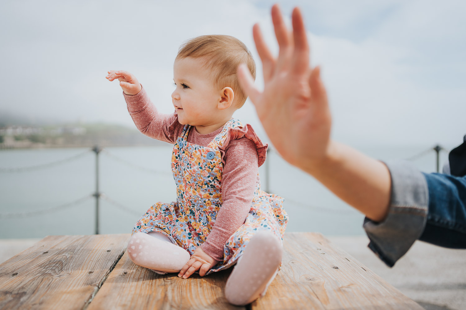 folkestone family photo shoot on the beach toddler girl sitting on picnic bench