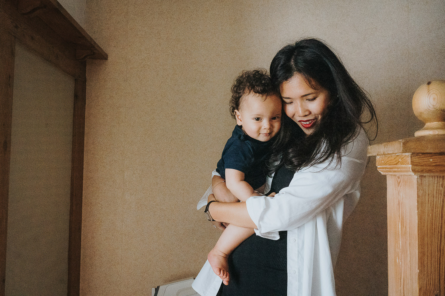 family photo shoot at home toddler boy with mum cuddling on stairs