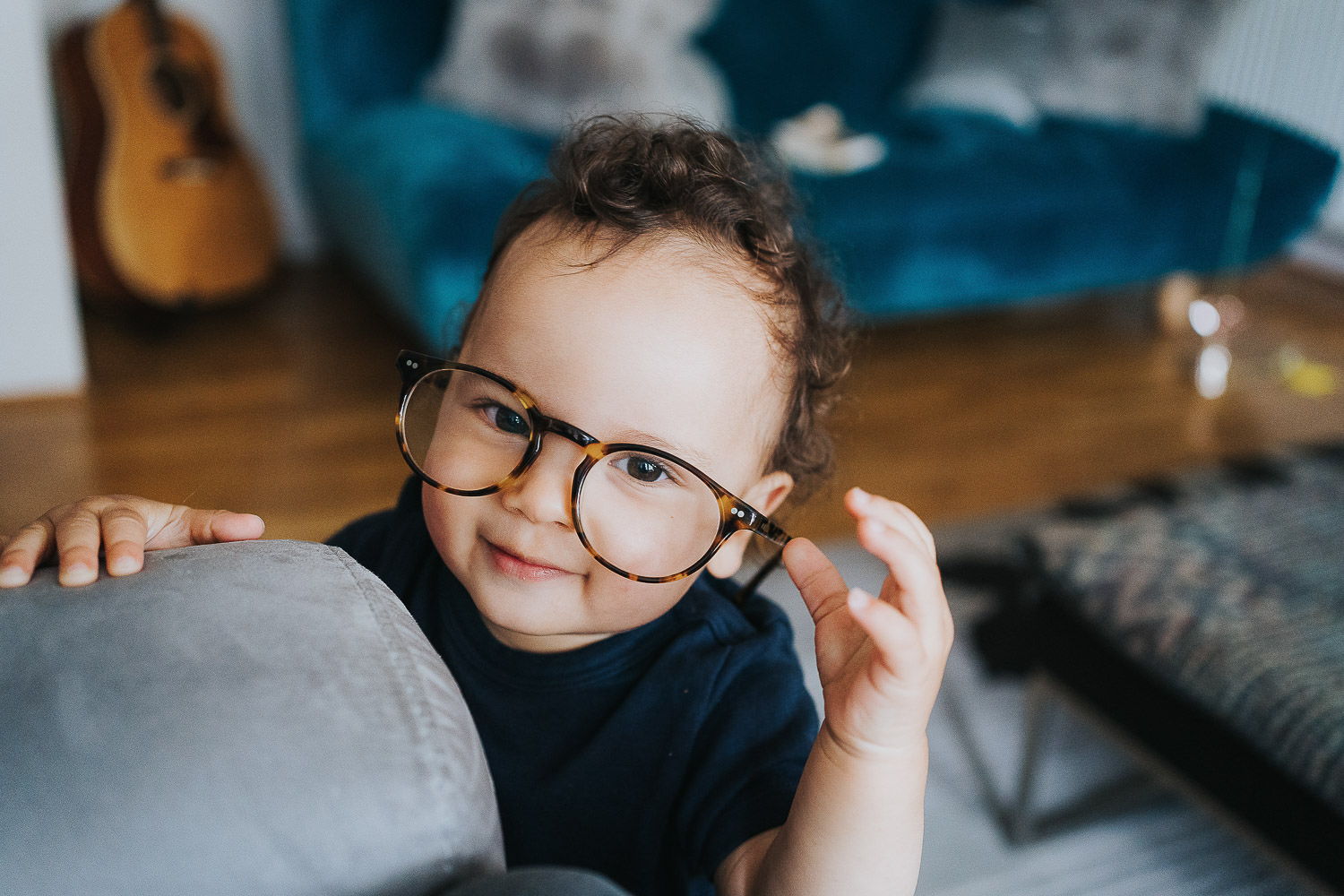 family photo shoot at home toddler boy trying on adults spectacles