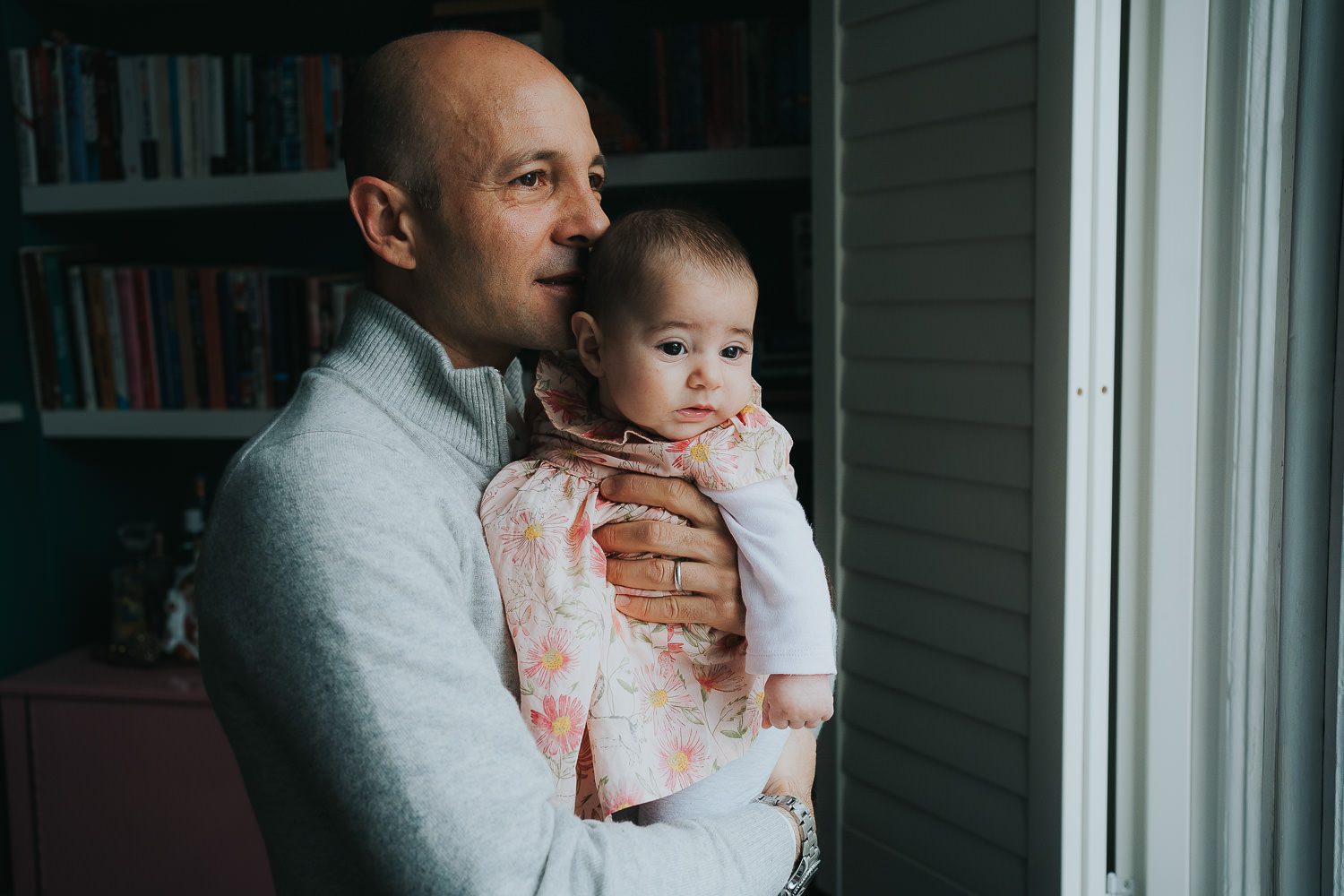 bayswater family photo shoot dad and baby at home looking out of the window