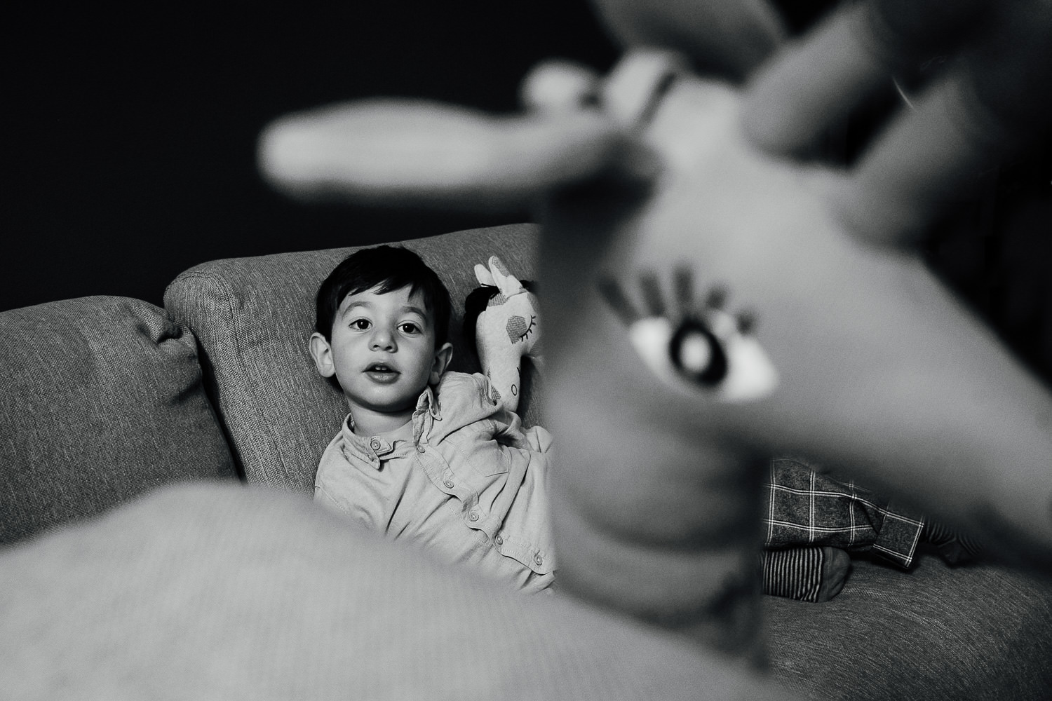 bayswater family photo shoot black and white shot of little boy on sofa with large giraffe soft toy