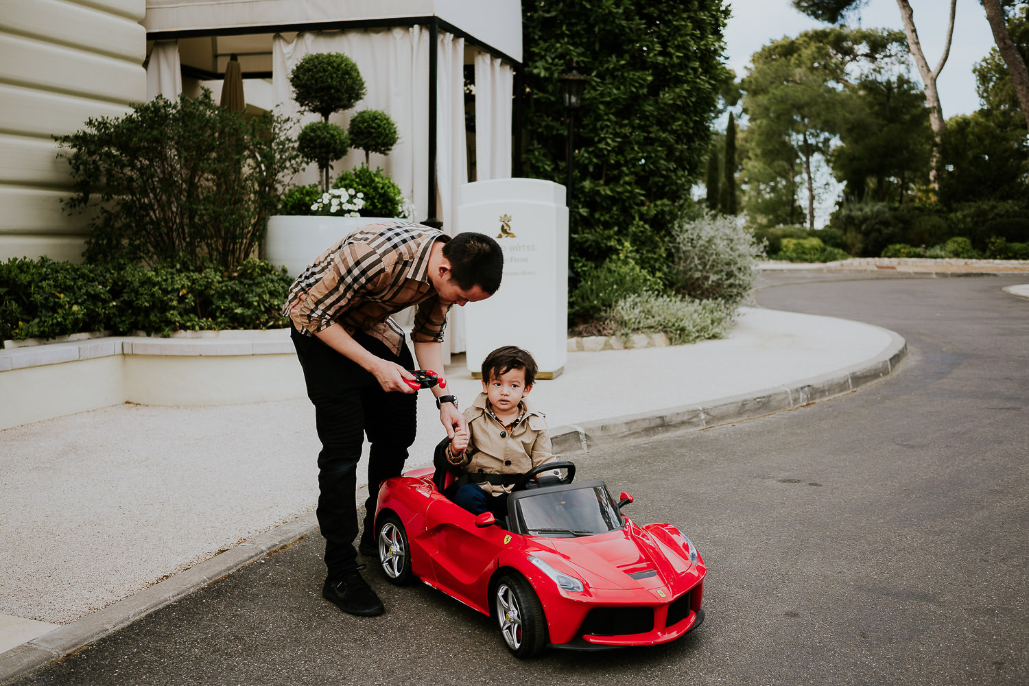 little boy driving kids sports car at a family vacation photo shoot in the south of france grand hotel du cap ferrat