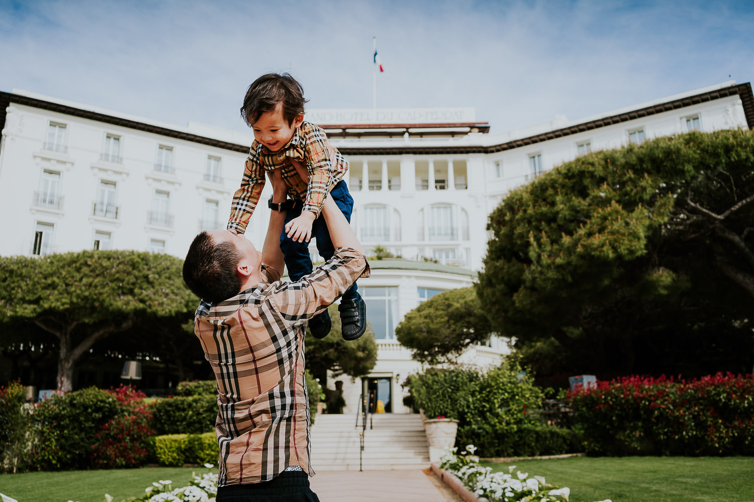 father and son in hotel gardens at a family vacation photo shoot in the south of france grand hotel du cap ferrat