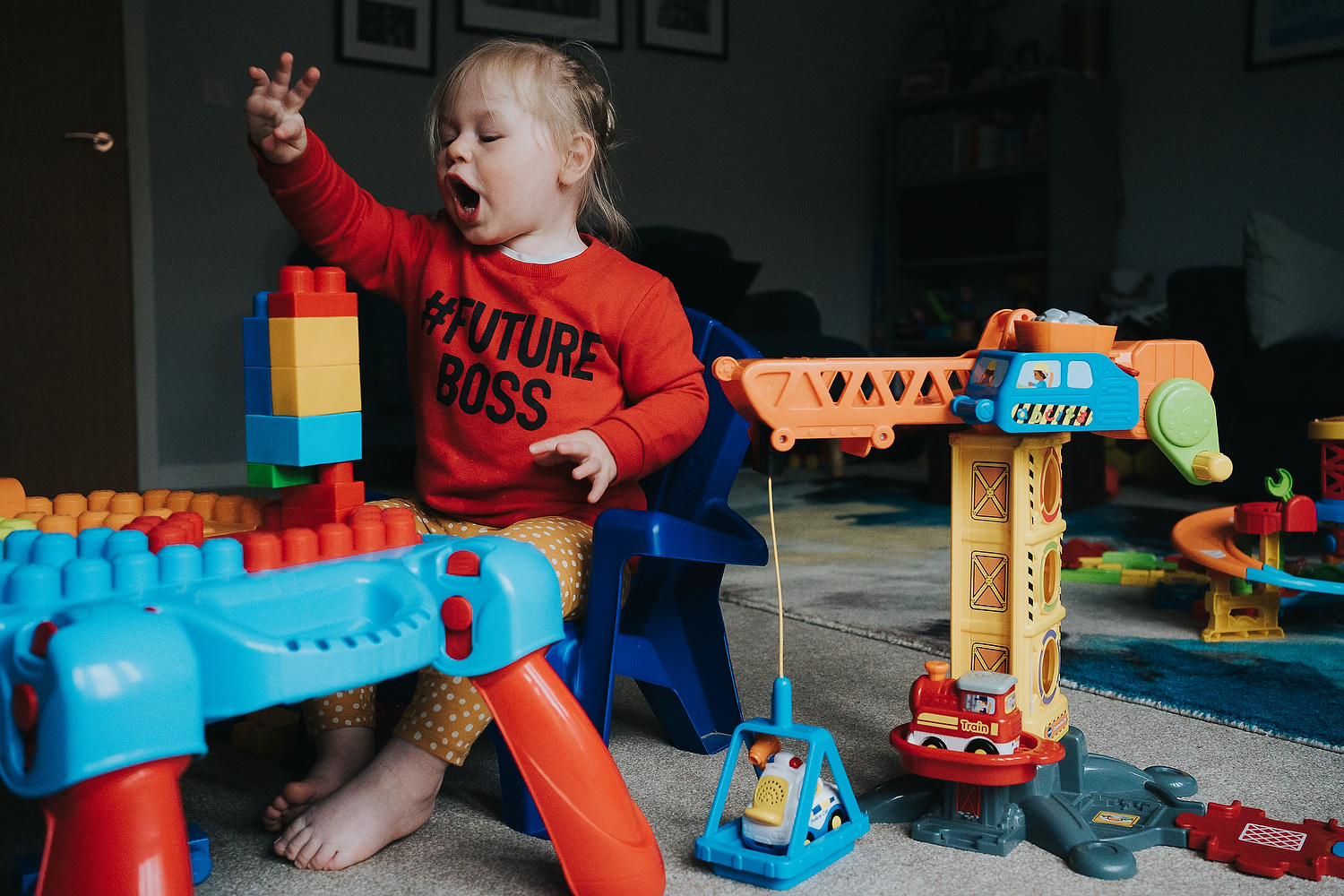 at home family photo shoots in london toddler girl playing with construction toys