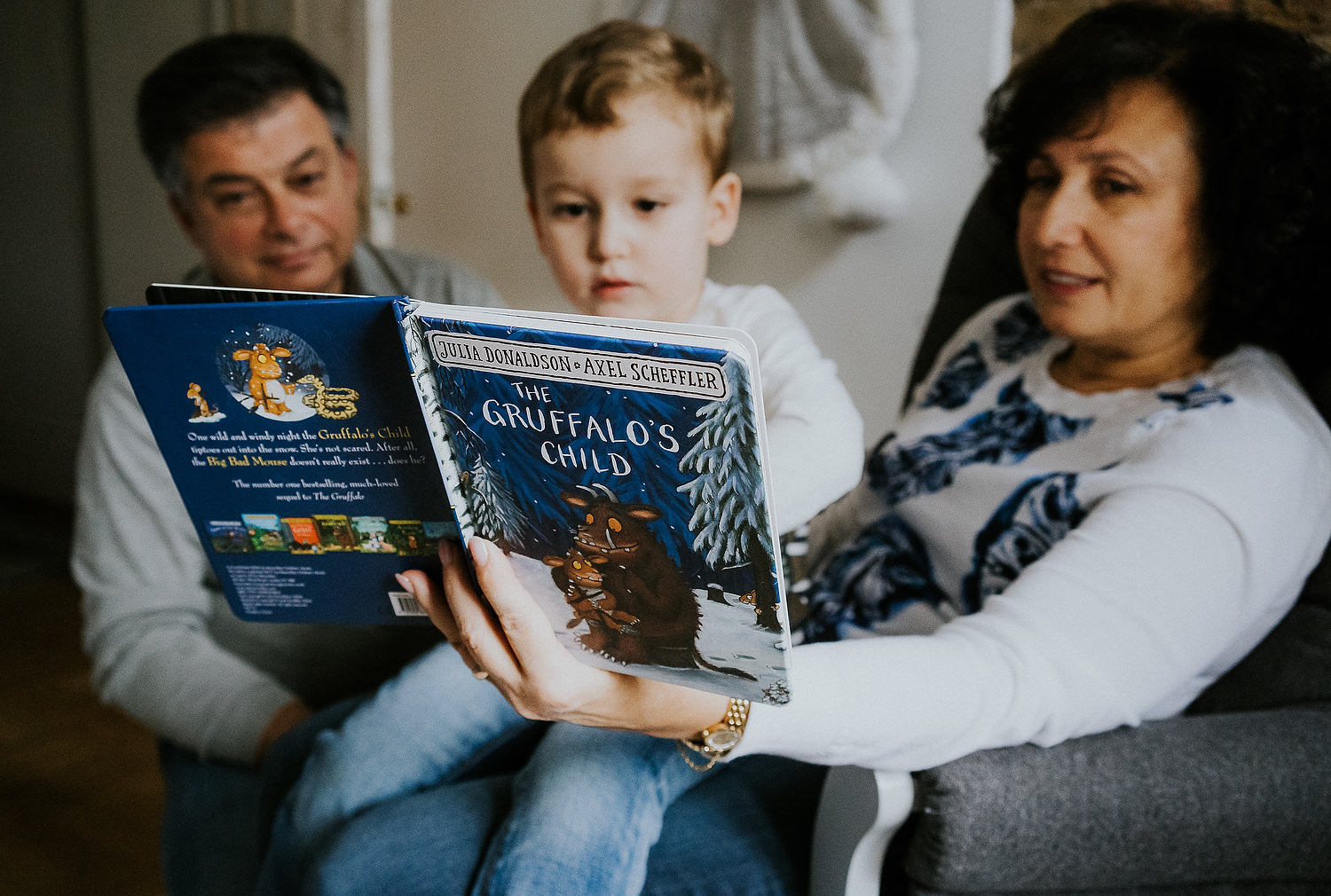 at home family photo shoots in london grandparents reading story to young boy