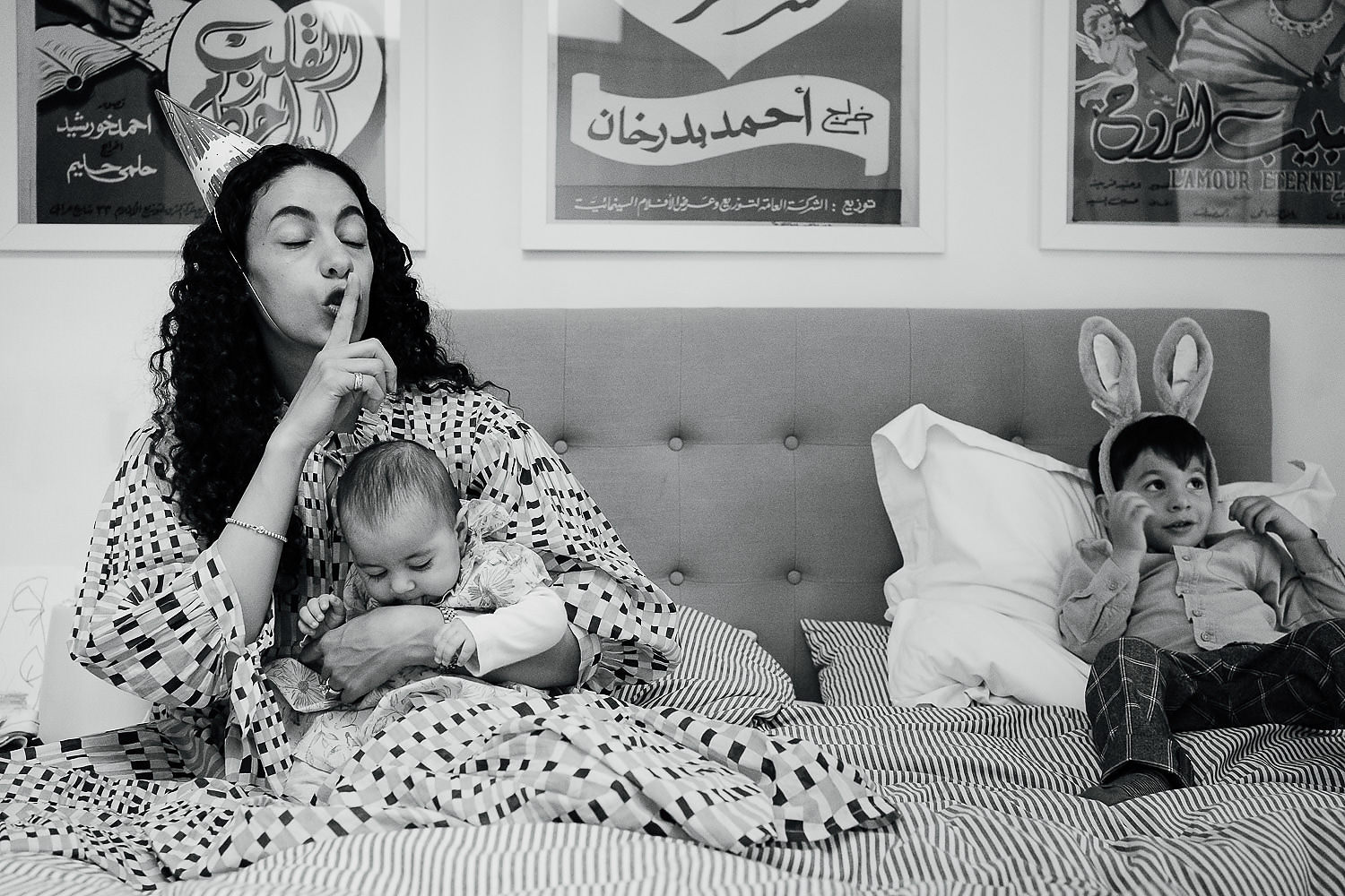 at home family photo shoots in london mother and two children playing in bed