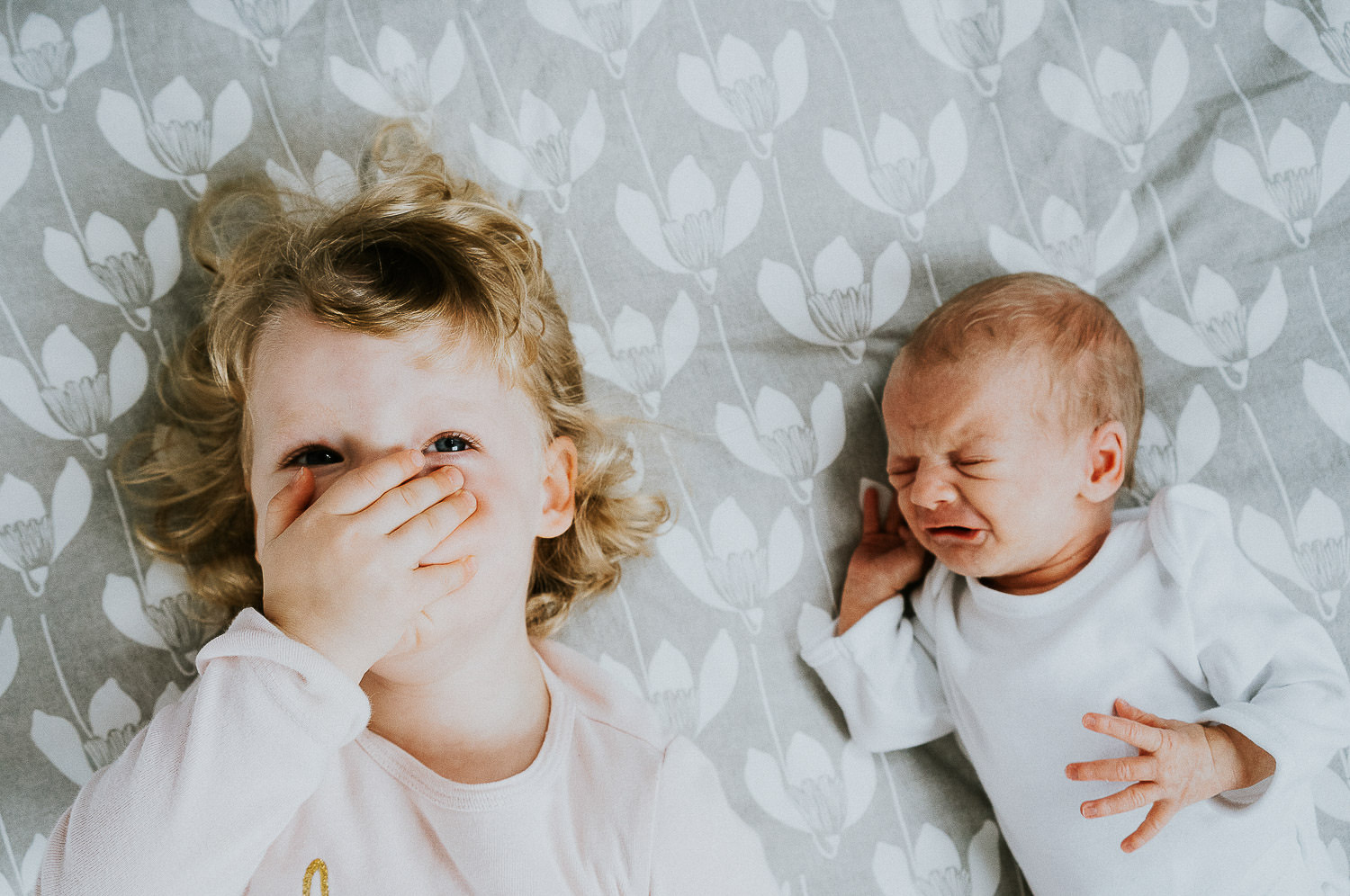 newborn photo shoot baby and sister on bed close up portrait