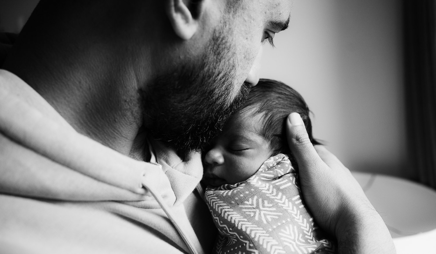father and baby son snuggling black and white photo