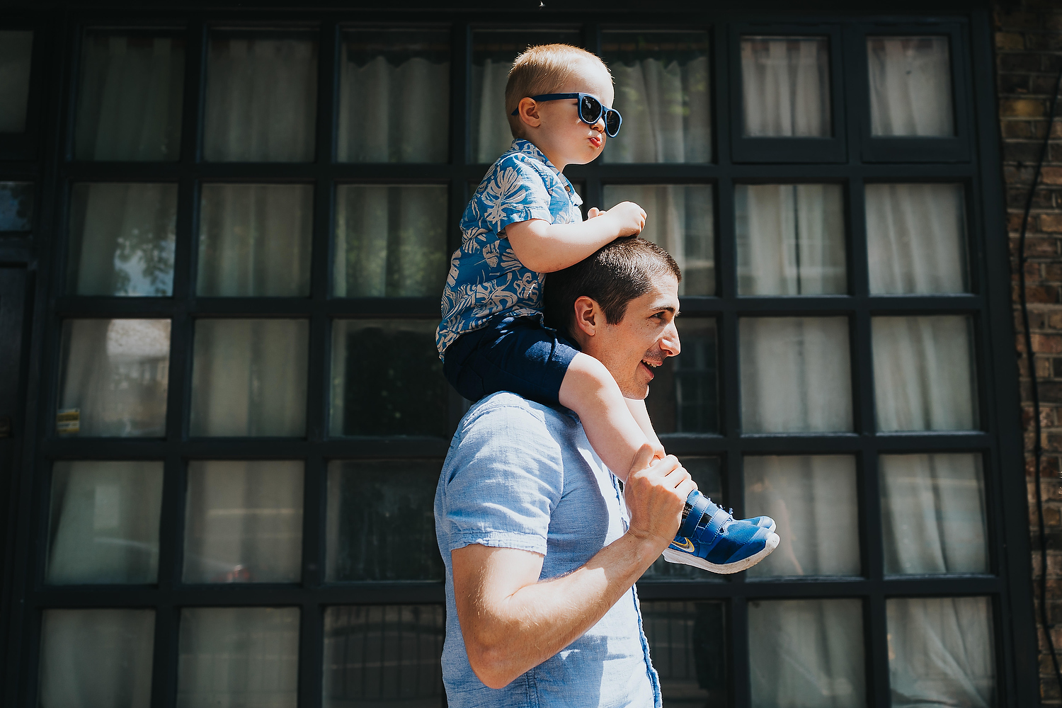 Spring Mini Shoot in London Father walking with toddler son on shoulders