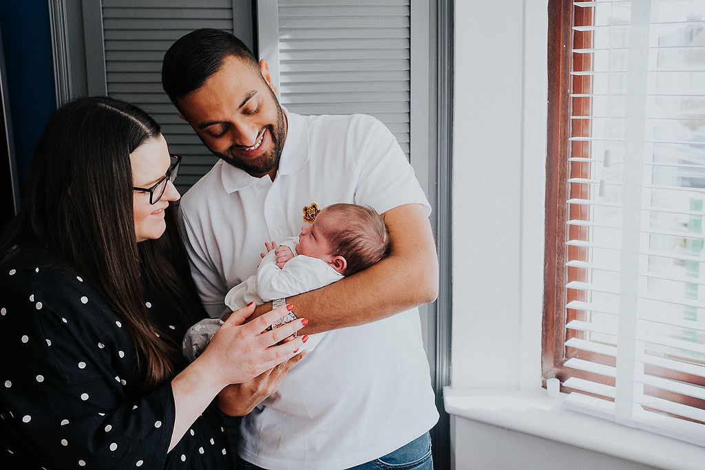 dad holding newborn with mum